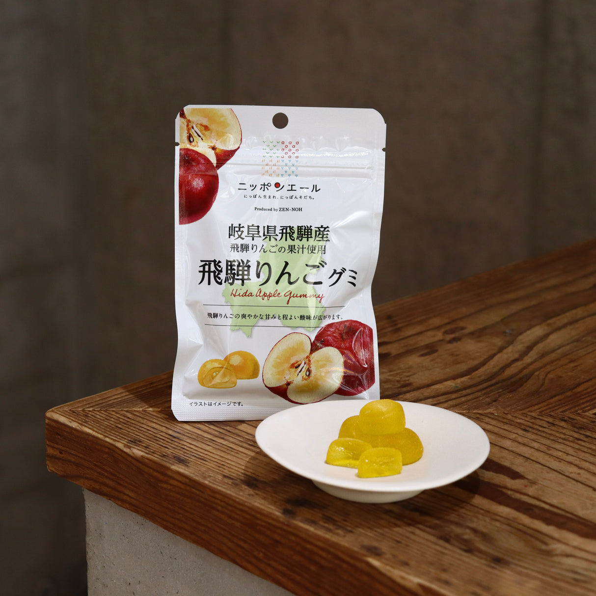 Packaged fruit gummies with a bowl of gummies on a wooden surface Gifu Hida Apple Gummy / 岐阜県飛騨産飛騨りんごグミ yunomi.life
